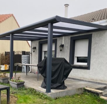 Pergola aluminium laquée gris anthracite sur terrasse en carrelage gris côté jardin